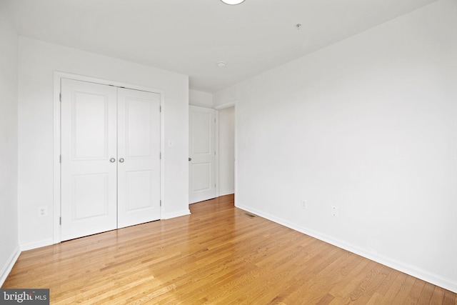 unfurnished bedroom featuring light hardwood / wood-style flooring and a closet