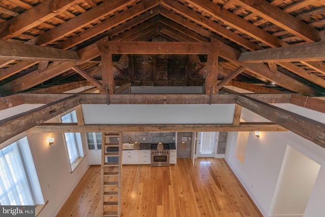 interior space with vaulted ceiling with beams, wooden ceiling, and light wood-type flooring