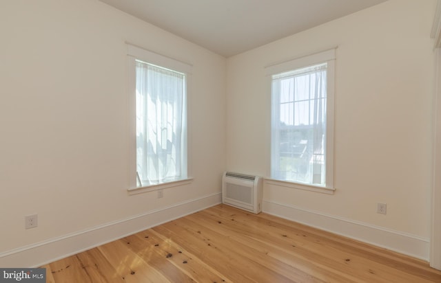 spare room featuring light hardwood / wood-style floors and an AC wall unit