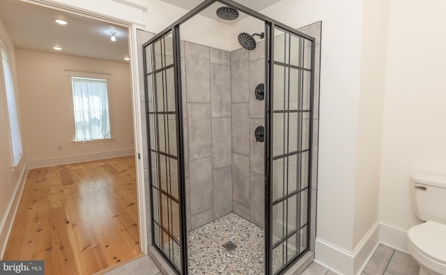 bathroom featuring a tile shower and toilet