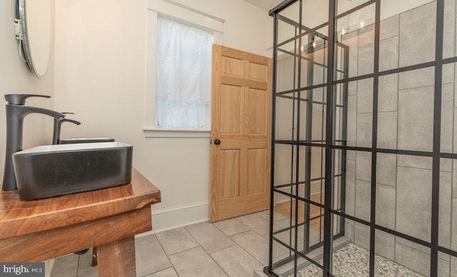 bathroom with a shower, tile patterned flooring, and sink