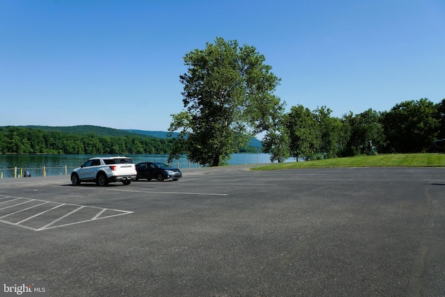 view of parking / parking lot with a water view