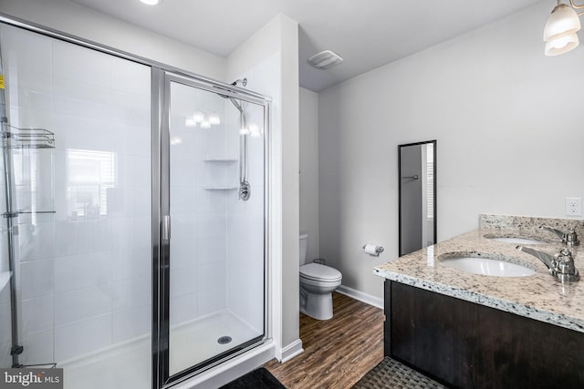 bathroom with toilet, vanity, an enclosed shower, and hardwood / wood-style flooring