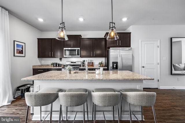 kitchen featuring a center island with sink, stainless steel appliances, and dark hardwood / wood-style floors