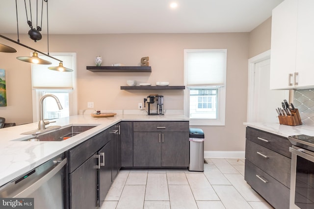 kitchen featuring a wealth of natural light, white cabinetry, sink, and appliances with stainless steel finishes