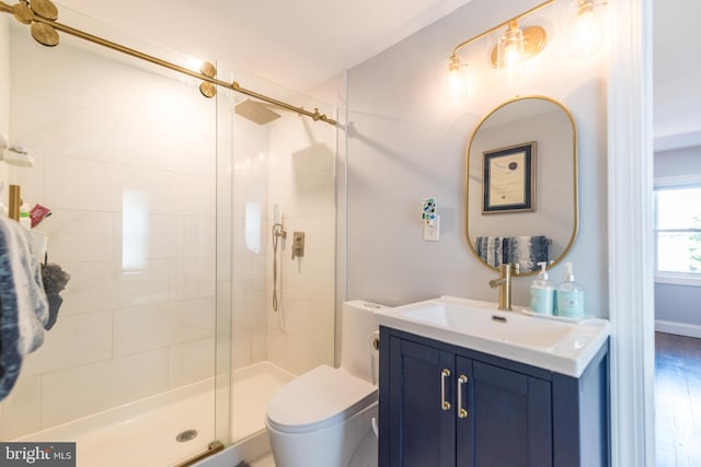 bathroom featuring a shower with door, vanity, wood-type flooring, and toilet