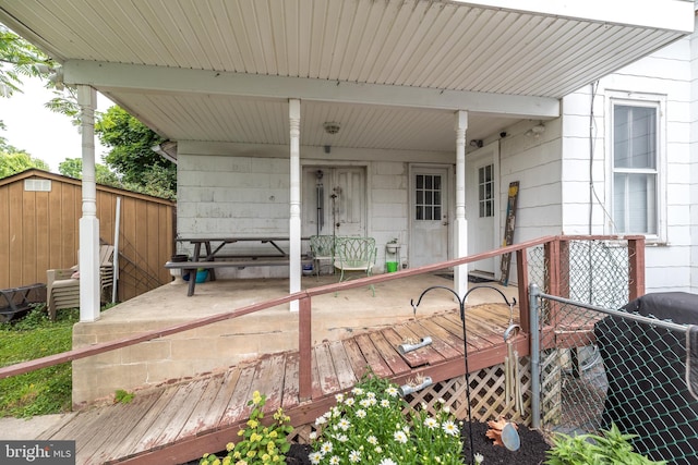 wooden terrace featuring area for grilling and a porch