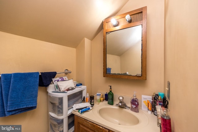 bathroom with vanity and lofted ceiling