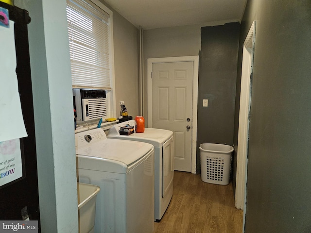 clothes washing area featuring washer and dryer, hardwood / wood-style flooring, and cooling unit