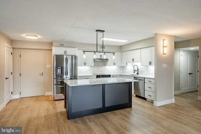 kitchen with pendant lighting, a center island, white cabinetry, and appliances with stainless steel finishes