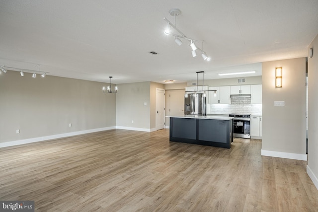 kitchen with rail lighting, hanging light fixtures, stainless steel appliances, light hardwood / wood-style flooring, and white cabinets