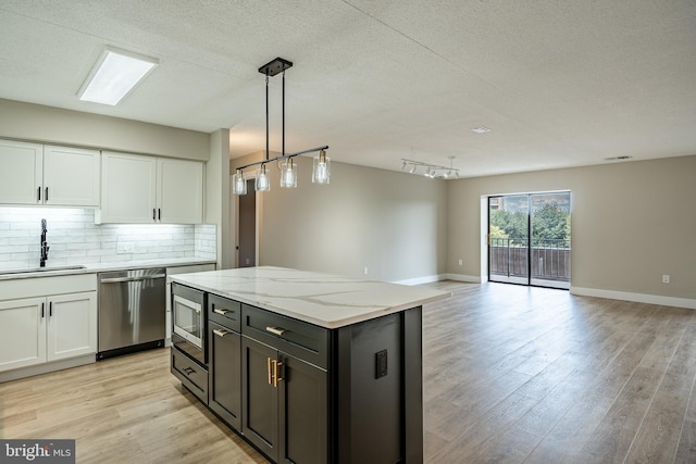 kitchen with white cabinets, light hardwood / wood-style floors, sink, and stainless steel appliances