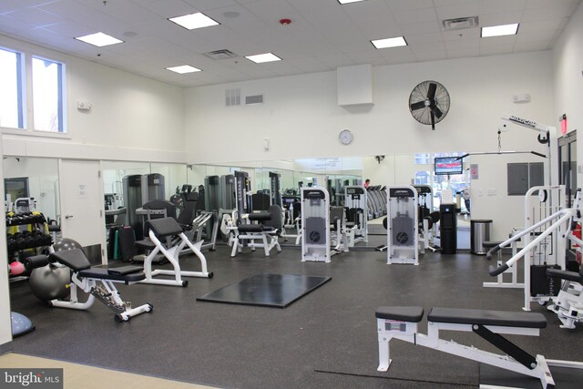 workout area with a paneled ceiling and a high ceiling