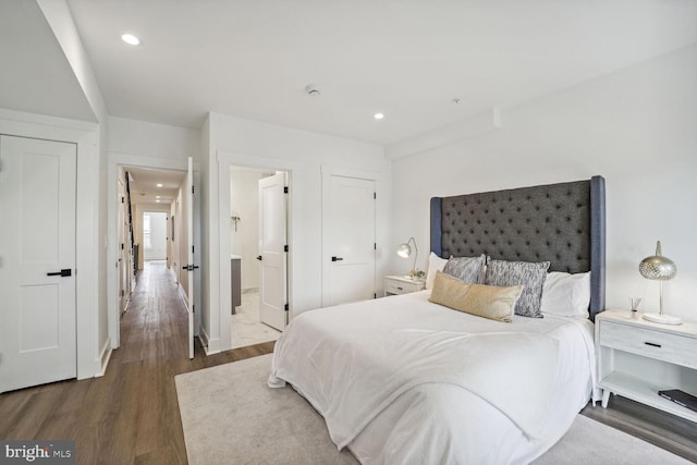 bedroom with dark hardwood / wood-style flooring and ensuite bath