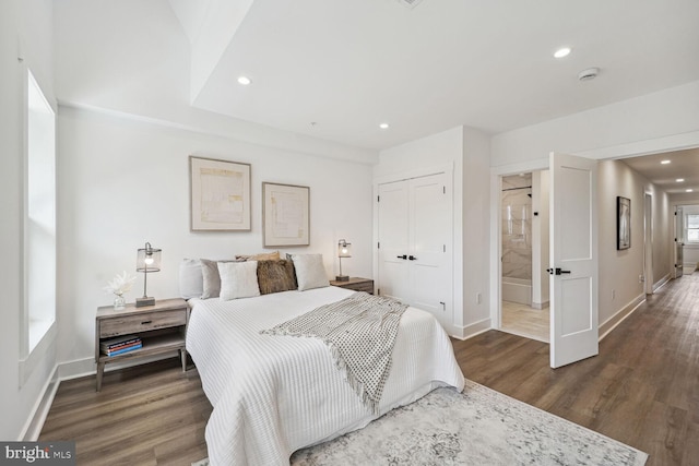 bedroom featuring dark hardwood / wood-style floors, a closet, and ensuite bath