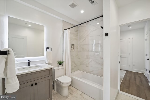 full bathroom featuring vanity, hardwood / wood-style flooring, toilet, and shower / bathtub combination with curtain