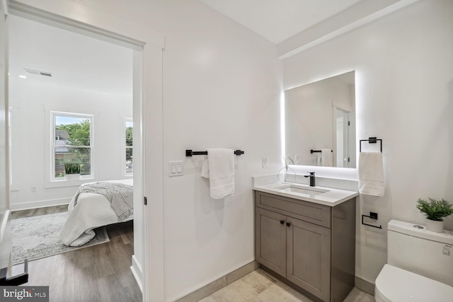 bathroom with hardwood / wood-style flooring, toilet, and vanity