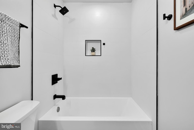 bathroom with tiled shower / bath combo and toilet