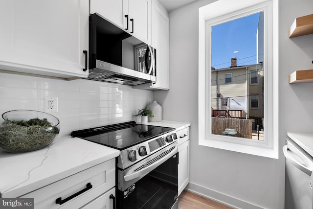 kitchen featuring light stone counters, white cabinetry, appliances with stainless steel finishes, and tasteful backsplash