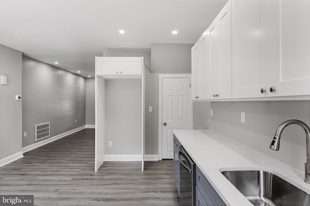 kitchen featuring white cabinets, light stone countertops, and sink