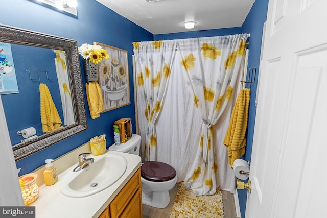 bathroom with hardwood / wood-style floors, vanity, and toilet