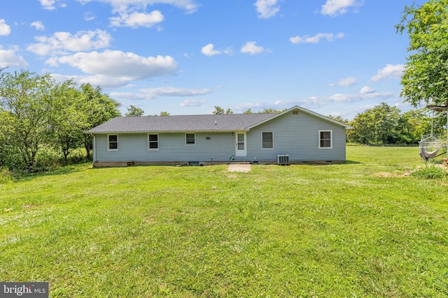 back of property with a lawn and central AC