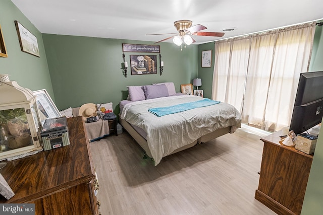 bedroom with ceiling fan and light hardwood / wood-style floors