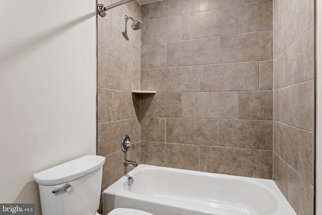 bathroom featuring tiled shower / bath combo and toilet