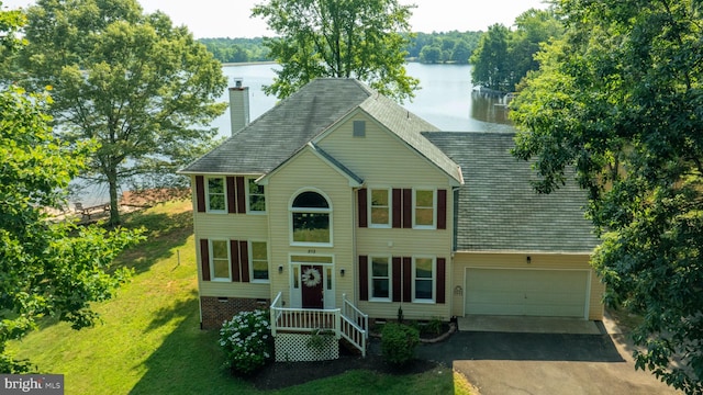 view of front of property featuring a water view, a front yard, and a garage