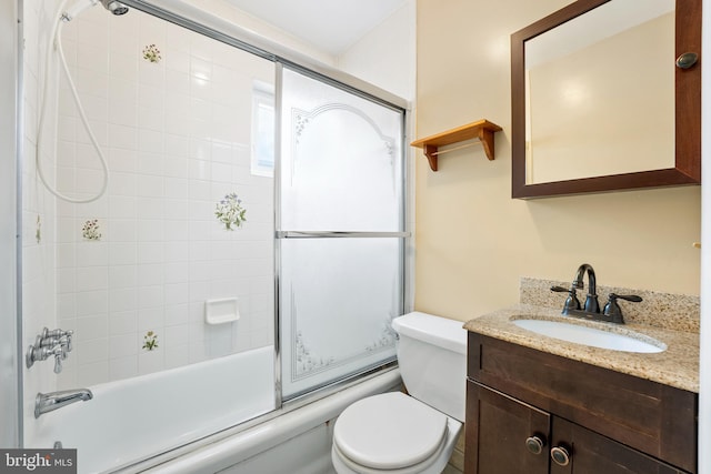 full bathroom with enclosed tub / shower combo, vanity, and toilet