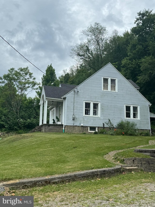 view of side of home with a porch and a yard