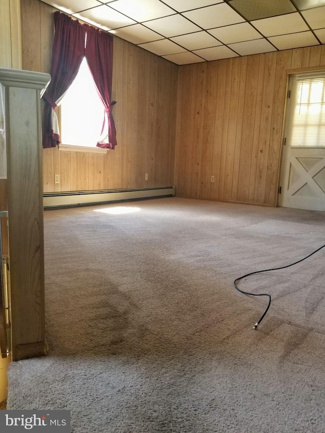 spare room with plenty of natural light, carpet floors, a baseboard radiator, and a drop ceiling