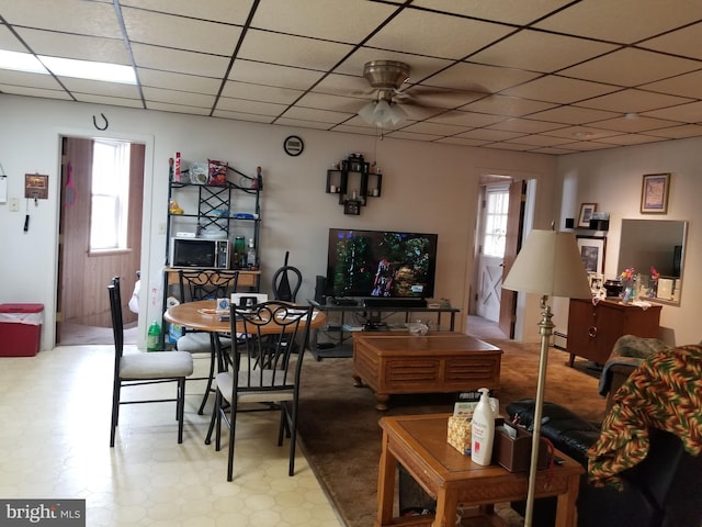 dining space with ceiling fan and a drop ceiling