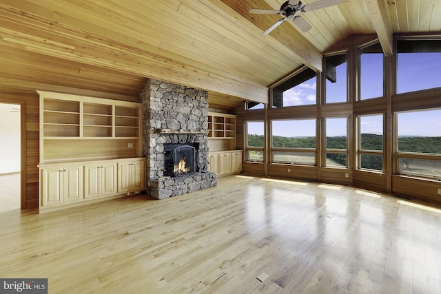 unfurnished living room with wooden ceiling, ceiling fan, a fireplace, beamed ceiling, and light hardwood / wood-style floors