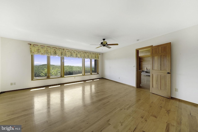 empty room featuring ceiling fan and light hardwood / wood-style flooring