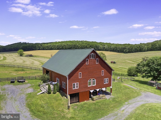 view of home's exterior with a rural view and an outdoor structure