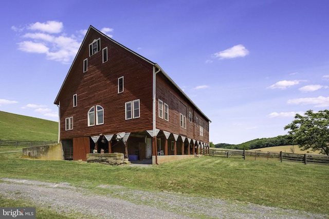 view of side of home with a yard and a rural view