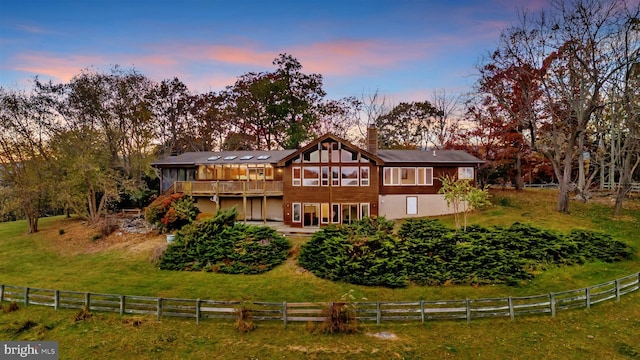 back house at dusk with a deck