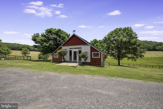 view of outdoor structure featuring a rural view and a lawn