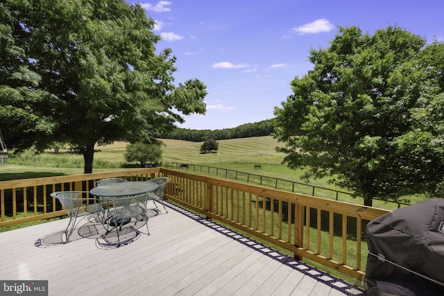 wooden deck with a grill and a rural view