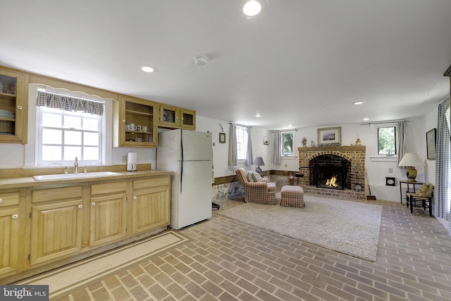 living room with a fireplace, plenty of natural light, and sink