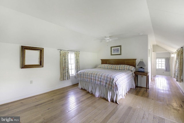 bedroom featuring ceiling fan, light wood-type flooring, and vaulted ceiling