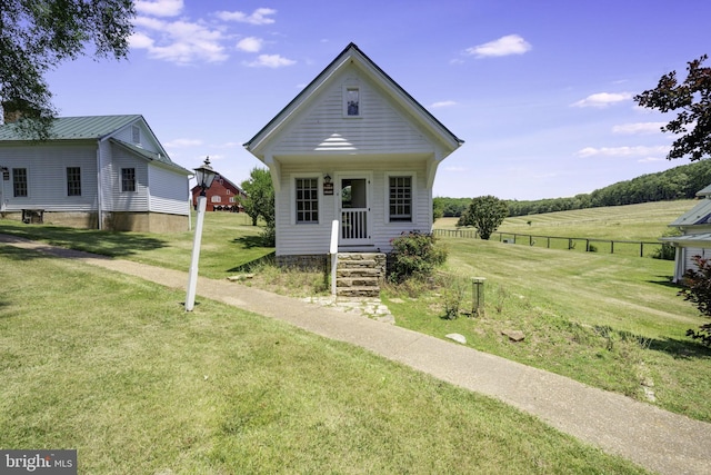 view of front facade featuring a rural view and a front lawn