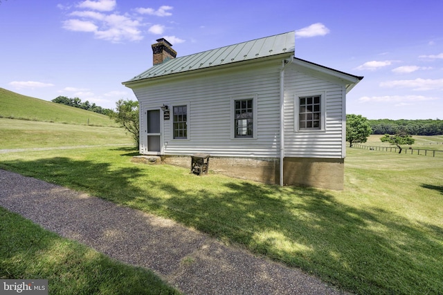 view of home's exterior featuring a lawn and a rural view