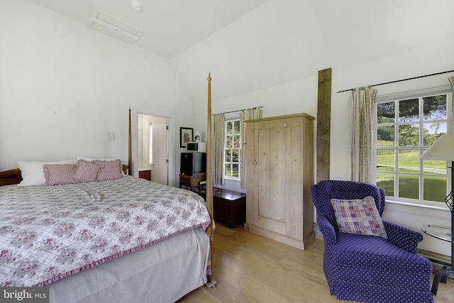 bedroom featuring vaulted ceiling and light wood-type flooring