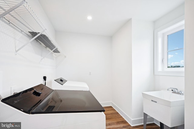 washroom featuring sink, washer and dryer, and wood-type flooring