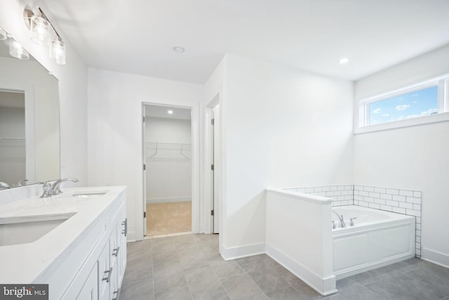 bathroom featuring vanity, tile patterned floors, and a washtub