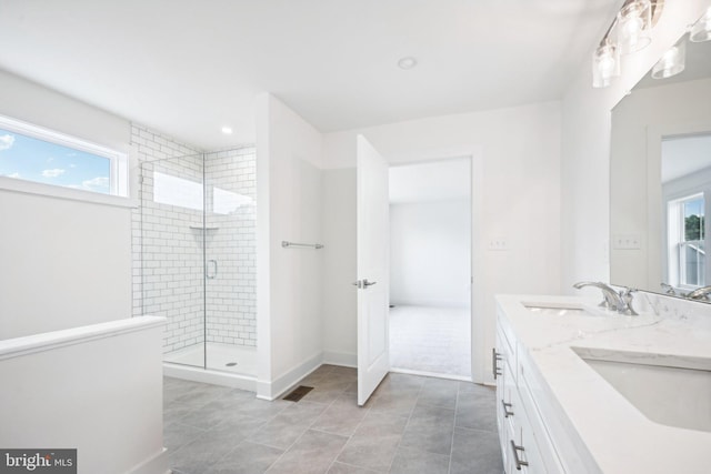 bathroom featuring tiled shower, vanity, and tile patterned flooring