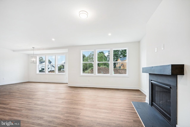 unfurnished living room featuring hardwood / wood-style flooring and a notable chandelier