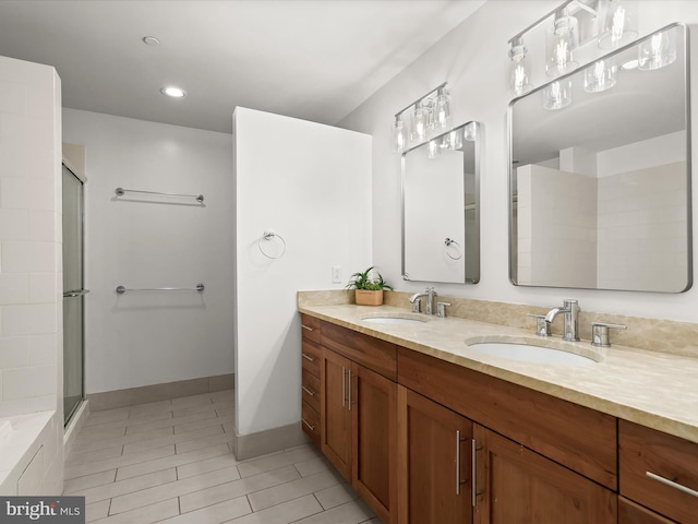 bathroom featuring a sink, an enclosed shower, baseboards, and double vanity